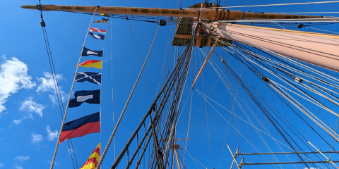 Semaphore flags on HMS Warrior spelling 'Play Up Pompey'